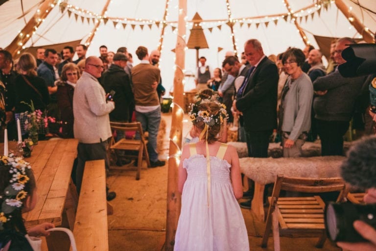 A wedding ceremony takes place on the clifftops in a Wild Tipi.